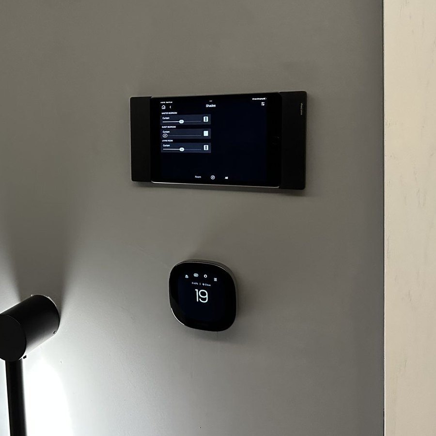 Control4 on a wall-mounted touch panel with a smart thermostat at Al Jaber Twin Tower